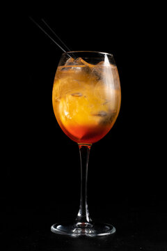Alcohol cocktail Fiero spritz. Low alcohol cocktail of martini, gin tonic, orange and ice in a transparent glass on a black background.
