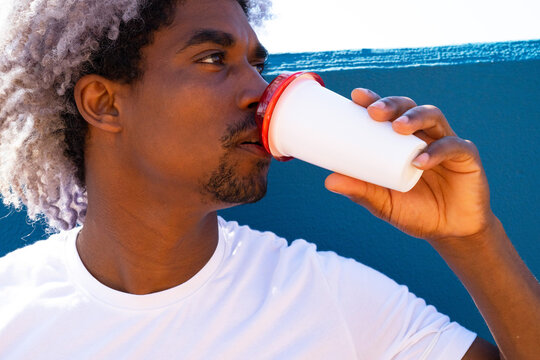 Black and afro man drinking a takeaway coffee latte. Takeaway coffee concept. Black businessman.