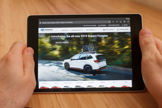SAN FRANCISCO, US - 1 April 2019: Close up to hands holding tablet using internet and looking through subaru web site, in San Francisco, California, USA. An illustrative editorial image.