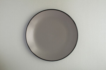 Top view of empty gray plate on the gray background
