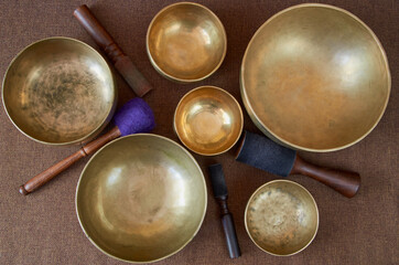 Sound healing music  instruments for meditation, relaxation, yoga, massage, sound healing - tibetan singing bowls with sticks on the dark background