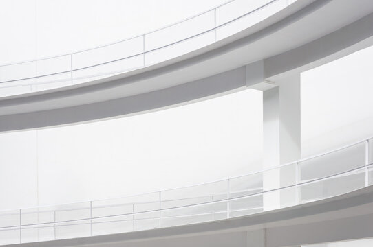 White smooth ramps or inclines with railings located outside modern futuristic building in sunlight