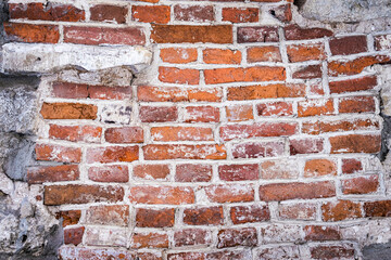 Old red brick masonry with traces of destroyed plaster.