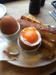 Solft boiiled egg with bread soldiers.  Boiled egg with toast for dipping.  Taken in a cafe