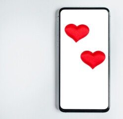 red hearts in the phone. concept love in correspondence