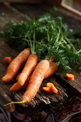 Fresh carrots with tops lying on a wooden table. Rustic. Carrots are a great element for vegans, keto and paleo diets. The concept of healthy eating.
