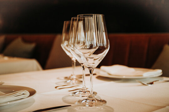 Shiny crystal beer goblets arranged in row on table with cutlery served for dinner in restaurant in Madrid