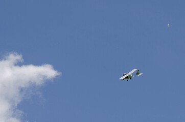 Small aircraft plane soars, flies in the sky among the clouds
