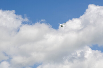 Small aircraft plane soars, flies in the sky among the clouds
