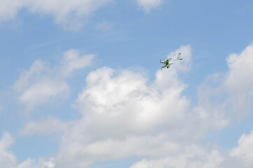 Small aircraft plane soars, flies in the sky among the clouds