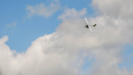 Small aircraft plane soars, flies in the sky among the clouds