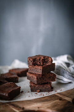 Yummy chocolate brownie pieces on cutting board on marble table at home