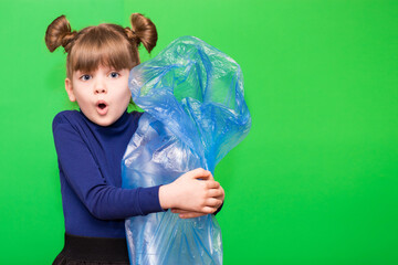 Girl hold trash bag and plastic bottle and shows interest in environmental issues isolated on green background. Child accustomed to bear responsibility for garbage since childhood.