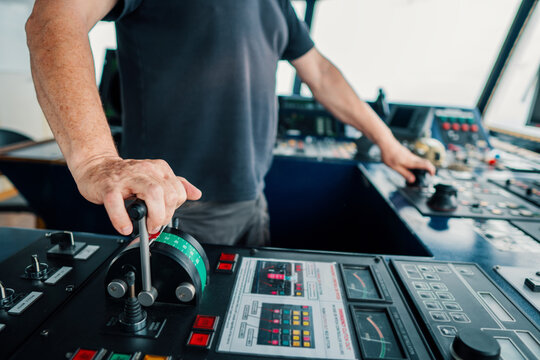 Captain of deck Officer on bridge of vessel or ship during navigaton watch at sea . He is maneuvering with cpp thrusters propulsion and bowthruster. Closeup view