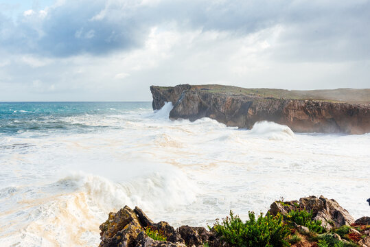 Spectacular scenery of foamy sea waving over rough rocky cliff on sunny day in Bufones de Llames Pr&radic;&ne;a in Spain