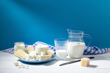 Dairy products on white wood base and blue background. - obrazy, fototapety, plakaty