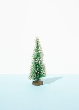 Miniature of decorative Christmas tree placed on table in studio on blue background