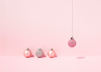 From above of decorative Christmas baubles arranged on pink background in studio for holiday celebration