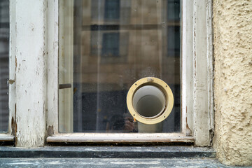 Lüftungsschlauch einer Klimaanlage am Fenster eines maroden Hauses in Prag