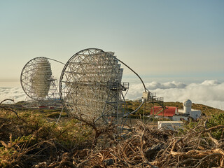 Amazing view of modern telescopes on dark mountaintop against cloudy sky at astronomical observatory on island of La Palma in Spain