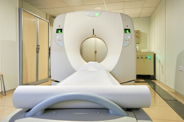 Contemporary computerized tomography scan machine with couch and gantry with control panel in clinic