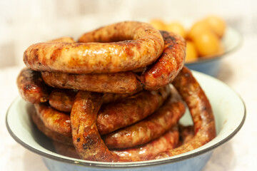 Homemade sausage. Sausage circles are stacked on a plate. Soft focus.