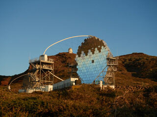 Various modern telescopes including MAGIC or Major Atmospheric Gamma Imaging Cherenkov Telescope located on hill slope at astronomical observatory on island of La Palma in Spain