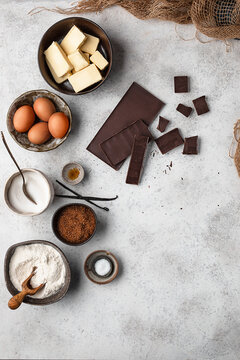 Top view set of various ingredients for traditional brownie cake recipe arranged on gray marble table
