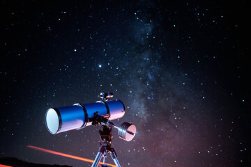 Modern optical telescope against cloudless dark sky with glowing stars at night time