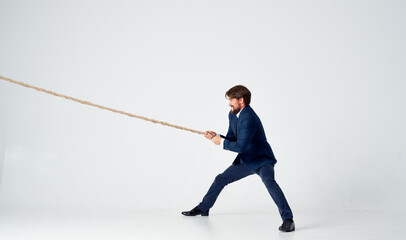 man with rope in hand on light background business finance advertising model