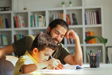 Doing home task with best daddy concept. Photo of two people positive patient intelligent daddy helping his  son with homework preparation and tests.