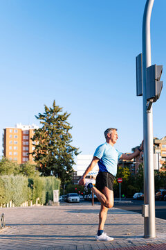 Retired senior man athlete stretching leg