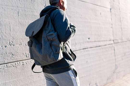 Senior retired man athlete walking with sportswear and backpack