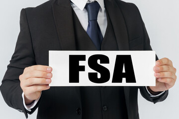 Obraz premium A businessman holds a sign in his hands which says FSA