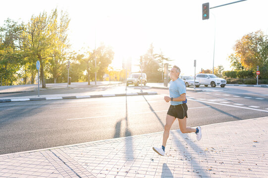 Senior retired man running through the city