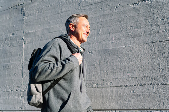 Senior retired man athlete walking with sportswear and backpack