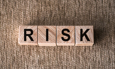 Fototapeta premium RISK. Word written on wooden blocks on a brown background.