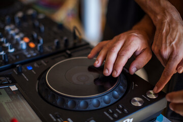 Hands of a DJ on a mixing console