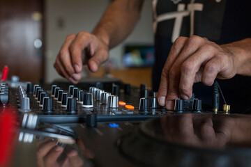 Hands of a DJ on a mixing console
