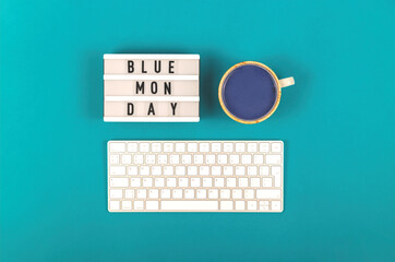 Blue Monday inscription among with keyboard and drink on a blue background. Depressive mood concept