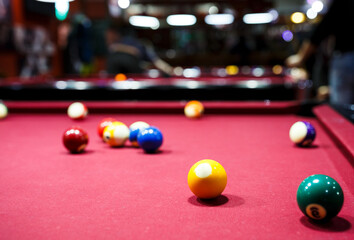 group of snooker multicolored balls lays on the table. Closeup view. Billiard red table with cue and balls. Leisure, hobby and entertainment concept