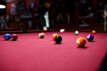 group of snooker multicolored balls lays on the table. Closeup view. Billiard red table with cue and balls. Leisure, hobby and entertainment concept