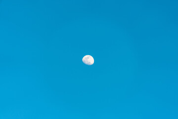 The moon in a big blue sky.