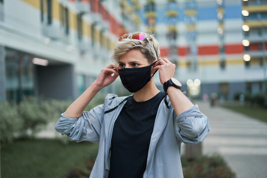 Woman in black medical mask outdoors in afternoon. Coronavirus epidemic