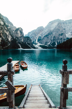 From above wooden quay on amazing scenery of lake with turquoise water in mountains on foggy day