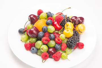 assortment of fresh berries on a white plate. useful vitamin healthy food fruit. healthy vegetable breakfast