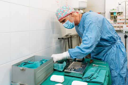 Veterinarian surgeon preparing tools for surgery before operation on a dog