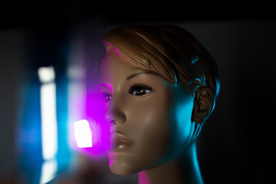 Creative image of mannequin woman in dark room with light effects