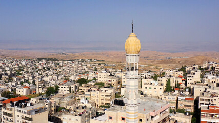 Fototapeta premium Mosque Tower minaret With Speakers in Jerusalem Beautiful Drone footage with Jordan desert mountain, Shuafat, Jeusalem 
