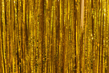 Festive tinsel of Golden color. The Golden rain as a background and texture.